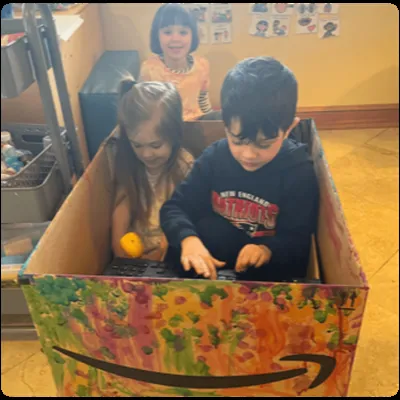 Children playing together in a decorated box